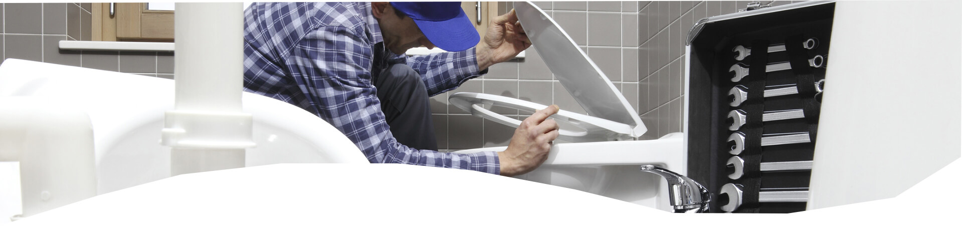 plumber performing toilet repair in home